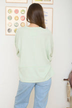 SPLIT NECK RAW EDGE LONG SLEEVE RIBBED KNIT TOP